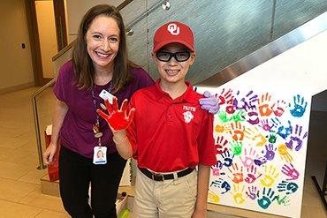 Twelve-year-old Christian added his handprint to the canvas as the 200th pediatric patient treated at Texas Center for Proton Therapy.